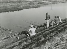 African American migrant laborers fishing in Belle Glade, Florida, January 1939. Creators: Farm Security Administration, Marion Post Wolcott.