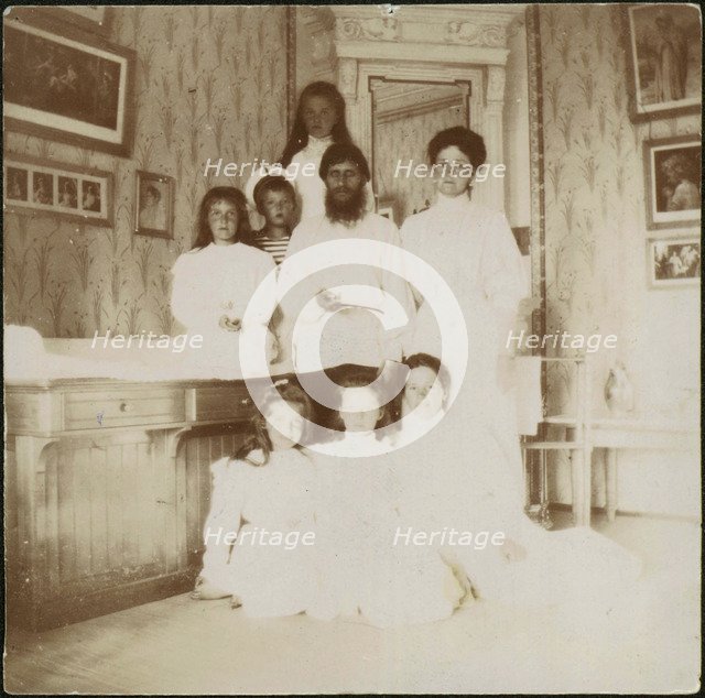 Grigory Rasputin with Empress Alexandra Fyodorovna, her five children and seated right governess Mar