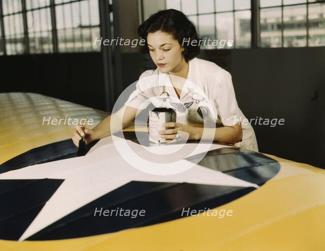Painting the American insignia on airplane wings is a job...Air Base, Corpus Christi, Texas, 1942. Creator: Howard Hollem.