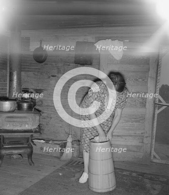 Wife of tobacco sharecropper cleaning butter churn, Person County, North Carolina, 1939. Creator: Dorothea Lange.