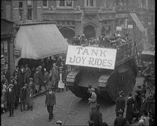 People Riding on Top of a Tank Down the Street. The Tank Bears a Sign Reading 'Tank Joy Rides', 1920 Creator: British Pathe Ltd.