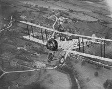 Man wing walking on an Avro 504 biplane without a harness, 20th century. Artist: Aerofilms.