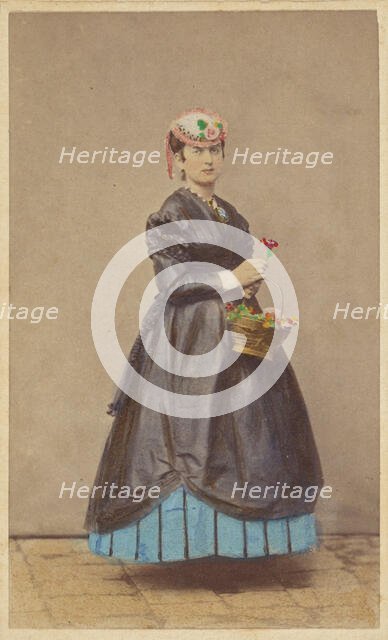 Unidentified woman wearing a flowered hat, holding single flower in one hand, basket of...1862-1865. Creator: Carlo Ponti.