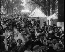 People Gathering and Relaxing at a Fairground Between Marquees and Balloons, 1920. Creator: British Pathe Ltd.