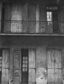 Facade of a building with shuttered doors and balcony, New Orleans or Charleston..., c1920-1926. Creator: Arnold Genthe.