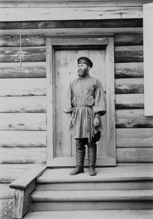 Portrait of an unknown man on the porch of a wooden house, 1900. Creators: I. A. Podgorbunskii, V. I. Podgorbunskii.