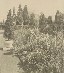 Gardener tending floral border, posed to...Rudyard Kipling's poem The Glory of the Garden, 1917. Creator: Frances Benjamin Johnston.
