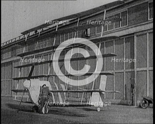 A Male Pilot Getting Into an Early Seven Winged Plane, 1922. Creator: British Pathe Ltd.