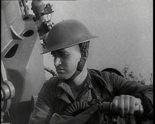 Close up of a Male British Soldier Wearing a Steel Helmet and Sitting Next to an Anti-Air..., 1939. Creator: British Pathe Ltd.