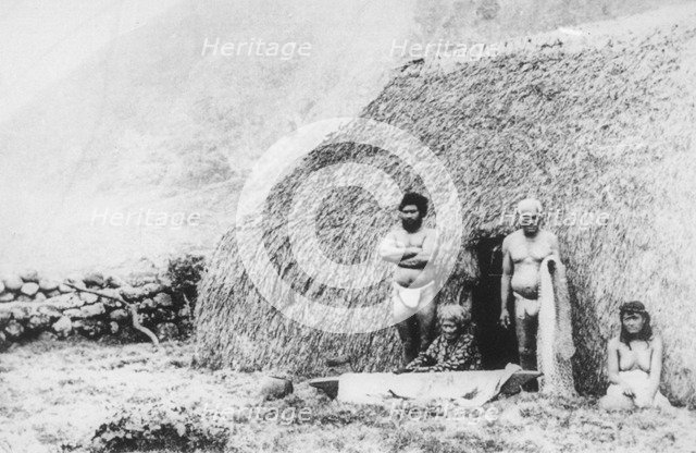 An old woman beating tapa in front of a pili grass house, Kalaupapa, Hawaii, 19th century. Artist: Unknown