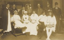 Amateur actors, some in drag, pose for a group portrait, (between 1910 and 1919?). Creator: Unknown.