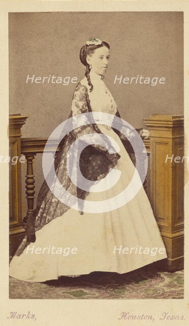 Unidentified woman wearing a white dress and black shawl, standing, 1870-1875. Creator: H. R. Marks.