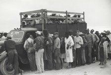 Vegetable pickers, migrants, waiting after work to be paid, near Homestead, Florida, February 1939. Creators: Farm Security Administration, Marion Post Wolcott.