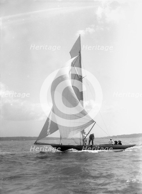 The 8 Metre 'Termagant' sailing with spinnaker, 1911. Creator: Kirk & Sons of Cowes.