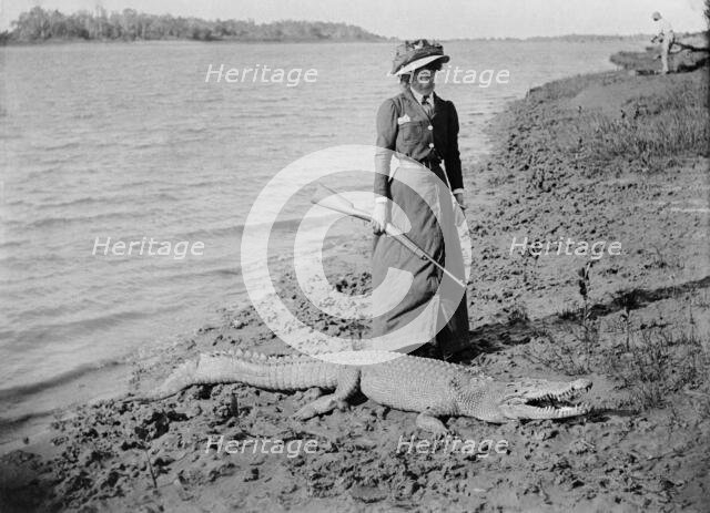Unknown lady with rifle and a saltwater crocodile, 1910. Creator: Robert Augustus Henry L'Estrange.