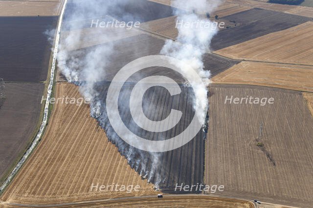 Fires in an arable field engulfing an electricty pylon, Amcotts, North Lincolnshire, 2022. Creator: Emma Trevarthen.