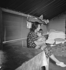 Mother with sick baby awaits arrival of FSA camp resident nurse, Tulare County, CA, 1939. Creator: Dorothea Lange.