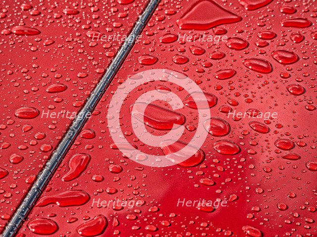 Raindrops beading on classic car paintwork