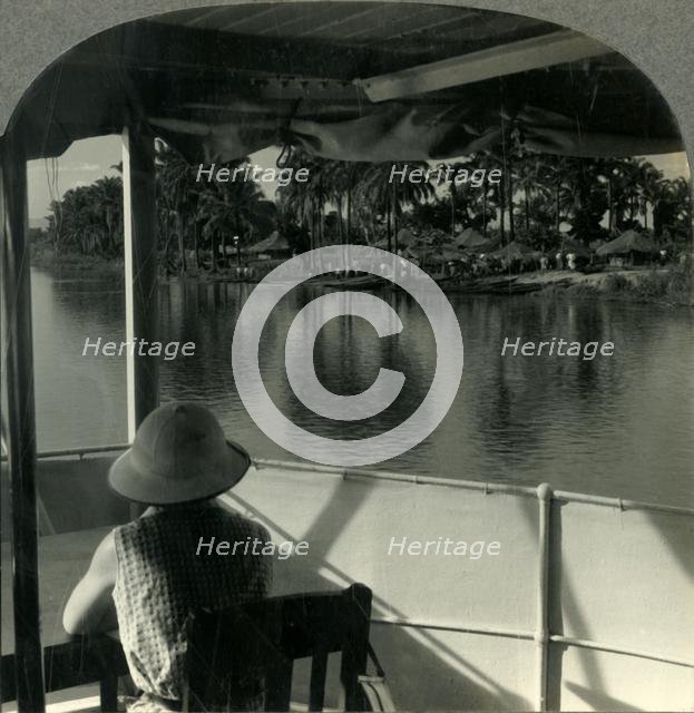 'On a Steamer on the Lualaba River, Belgian Congo - A Native Village at the Water's Edge', c1930s. Creator: Unknown.