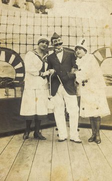 Three sailors, two in drag wearing pierrette costumes, pose on deck, c1910s. Creator: Unknown.