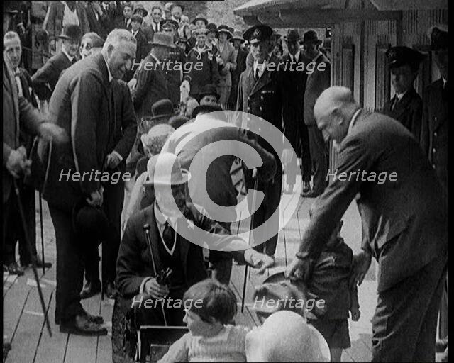 King George V of the United Kingdom Sitting On a Model Train With a Crowd of People Watching, 1924. Creator: British Pathe Ltd.