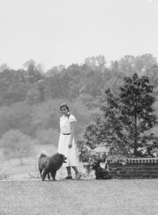 Brady, Victoria, Miss, with dogs, standing outdoors, 1931 July 14. Creator: Arnold Genthe.