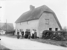 People standing outside a thatched cottage, Uffington, Oxfordshire, 1916. Artist: Henry Taunt