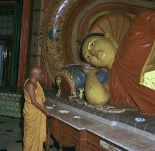 Buddhist priest before the image of a reclining Buddha. Artist: Unknown