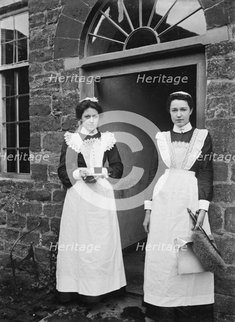 Two housemaids standing in the doorway of a house, Byfield, Northamptonshire, c1896-c1920. Artist: A Newton