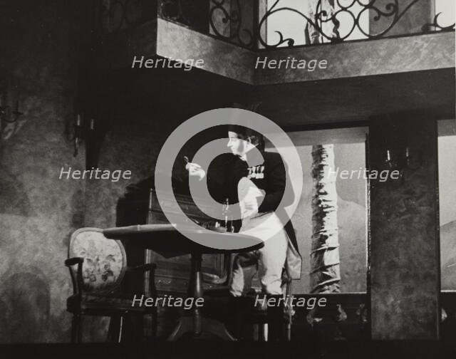Man standing by table, 1938. Creator: Unknown.