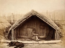 New Zealand: a Maori man sitting in front of a traditional house, between 1800 and 1899. Creator: Unknown.