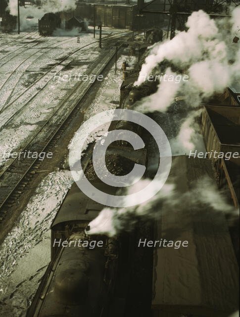 Locomotives lined up for coal, sand and water at the coaling station in the 40..., Chicago, 1942. Creator: Jack Delano.