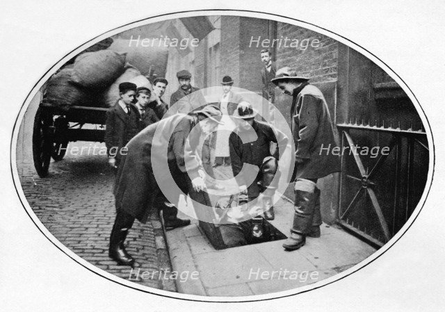 Sewermen going below, London, c1903 (1903). Artist: Unknown.