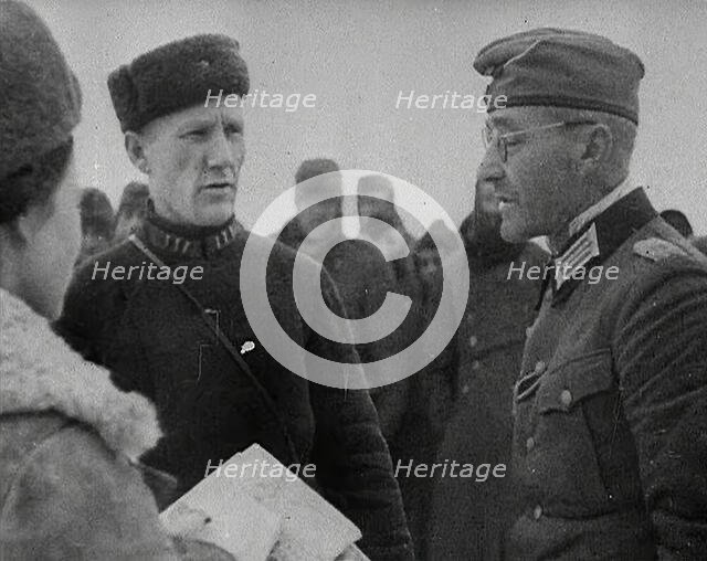 Two Russian Soldiers Talking to a German Prisoner of War, 1941. Creator: British Pathe Ltd.