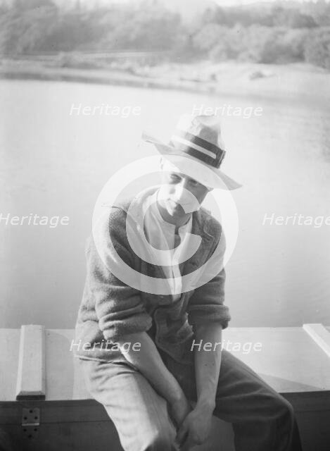 Unidentified man, seated in front of water, between 1896 and 1942. Creator: Arnold Genthe.