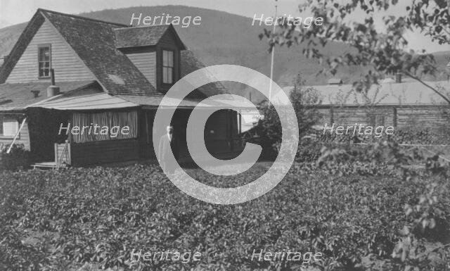 Man in frontyard of house, between c1900 and 1916. Creator: Unknown.