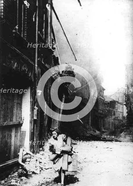 A woman leaving her burning house in a bombed street, Germany, 1945. Artist: Unknown