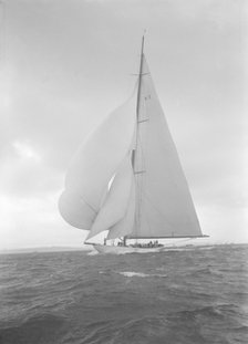 The 23-metre cutter 'Astra' sailing with spinnaker, 1932. Creator: Kirk & Sons of Cowes.