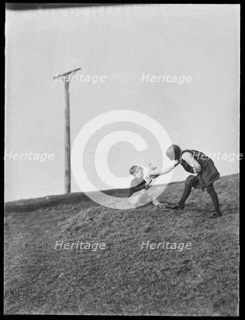 Two children playing in front of Combe Gibbet, Inkpen Hill, Inkpen, West Berkshire, 1925-1935. Creator: George R Long.