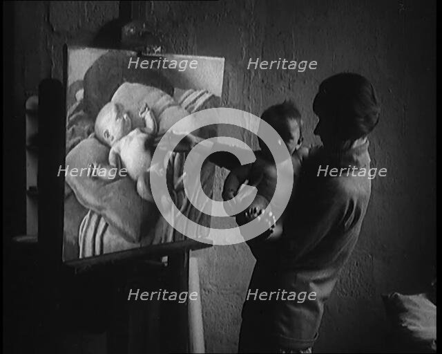 A Female Civilian Holding a Nude Child in Her Arms in front of a Painting of a Nude Child, 1920. Creator: British Pathe Ltd.
