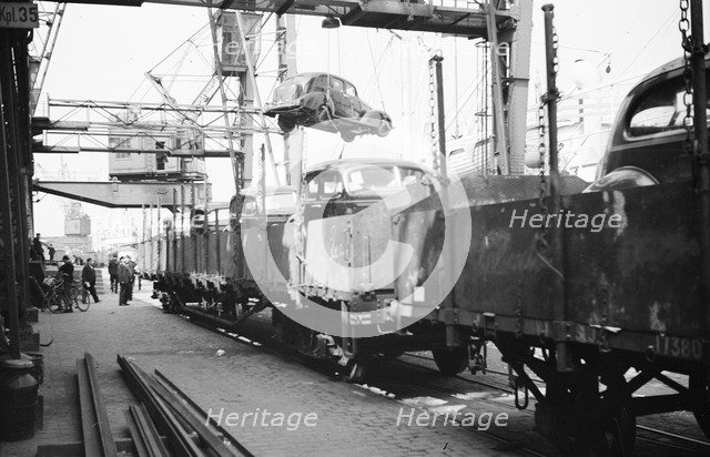 Imported cars being loaded onto railway goods wagons, Landskrona Harbour, Sweden, 1935. Artist: Unknown