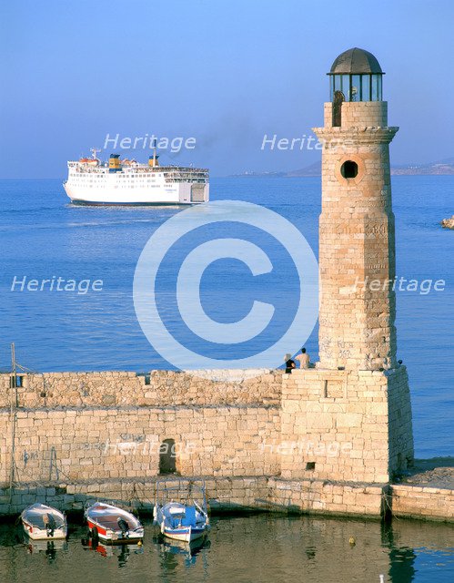 Venetian lighthouse and the ferry to Piraeus, Rethymnon, Crete, Greece.