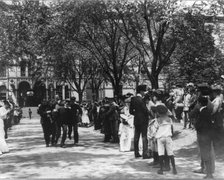 U.S. Naval Academy, Annapolis: 4 midshipmen carrying a man; crowd of guests along sidewalk, (1902?). Creator: Frances Benjamin Johnston.