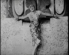 A Female Actor Chained to a Wall for a Performance, She Is Wearing a Glamorous Dress, 1922. Creator: British Pathe Ltd.