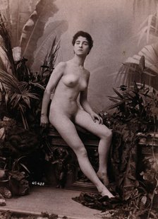 A young woman seated on a low balustrade posing naked, c1900. Creator: Unknown.