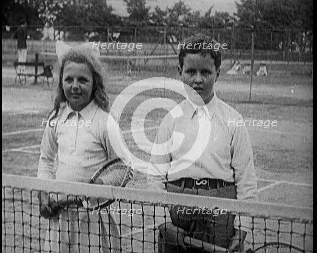 British Tennis Player Betty Nuttall as a Child, Standing on a Tennis Court With a Young Boy, 1921. Creator: British Pathe Ltd.