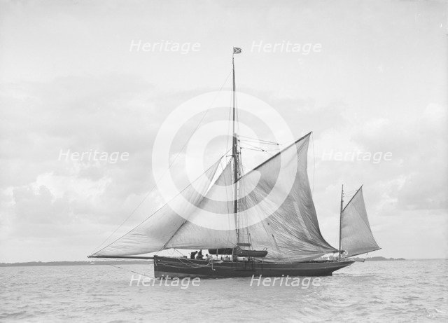The yawl 'Roma' raising main sail, 1912. Creator: Kirk & Sons of Cowes.