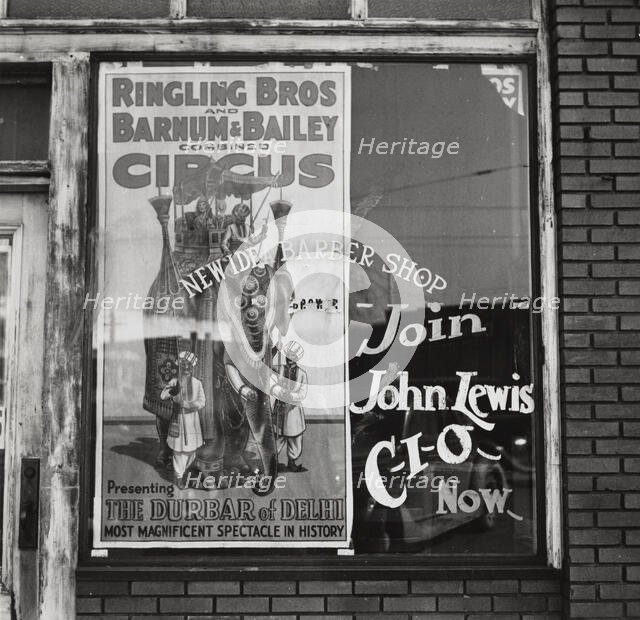 Barber shop window [with circus poster] in Birmingham, Alabama,  1937-01 - 1937-02. Creator: Arthur Rothstein.