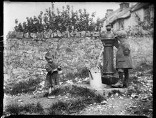 Two children collecting water at a water pump, Cheddar, Somerset, 1907. Creator: Katherine J Macfee.
