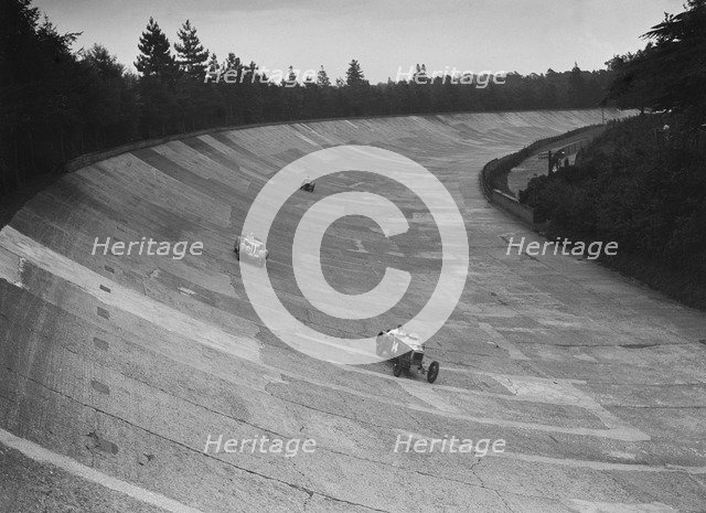 Frazer-Nash and Frazer-Nash BMW racing on the banking at Brooklands, 1938 or 1939. Artist: Bill Brunell.